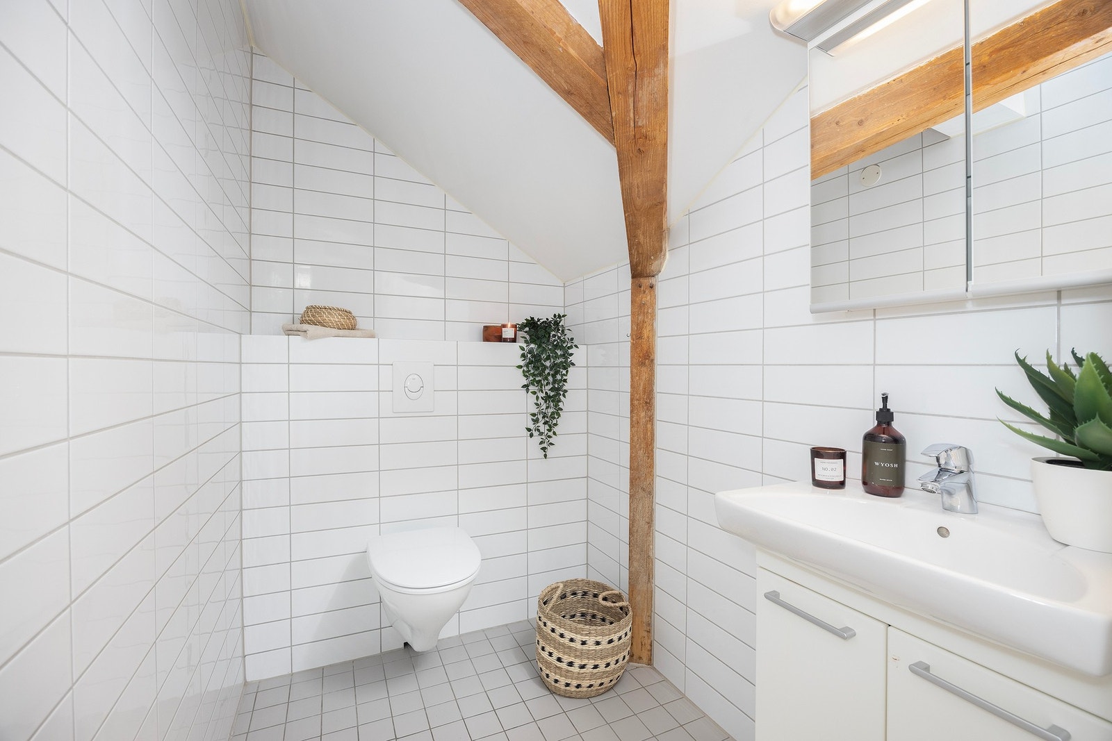 Toalettrom med vegghengt wc, servant og flislagte flater. Galleribilde