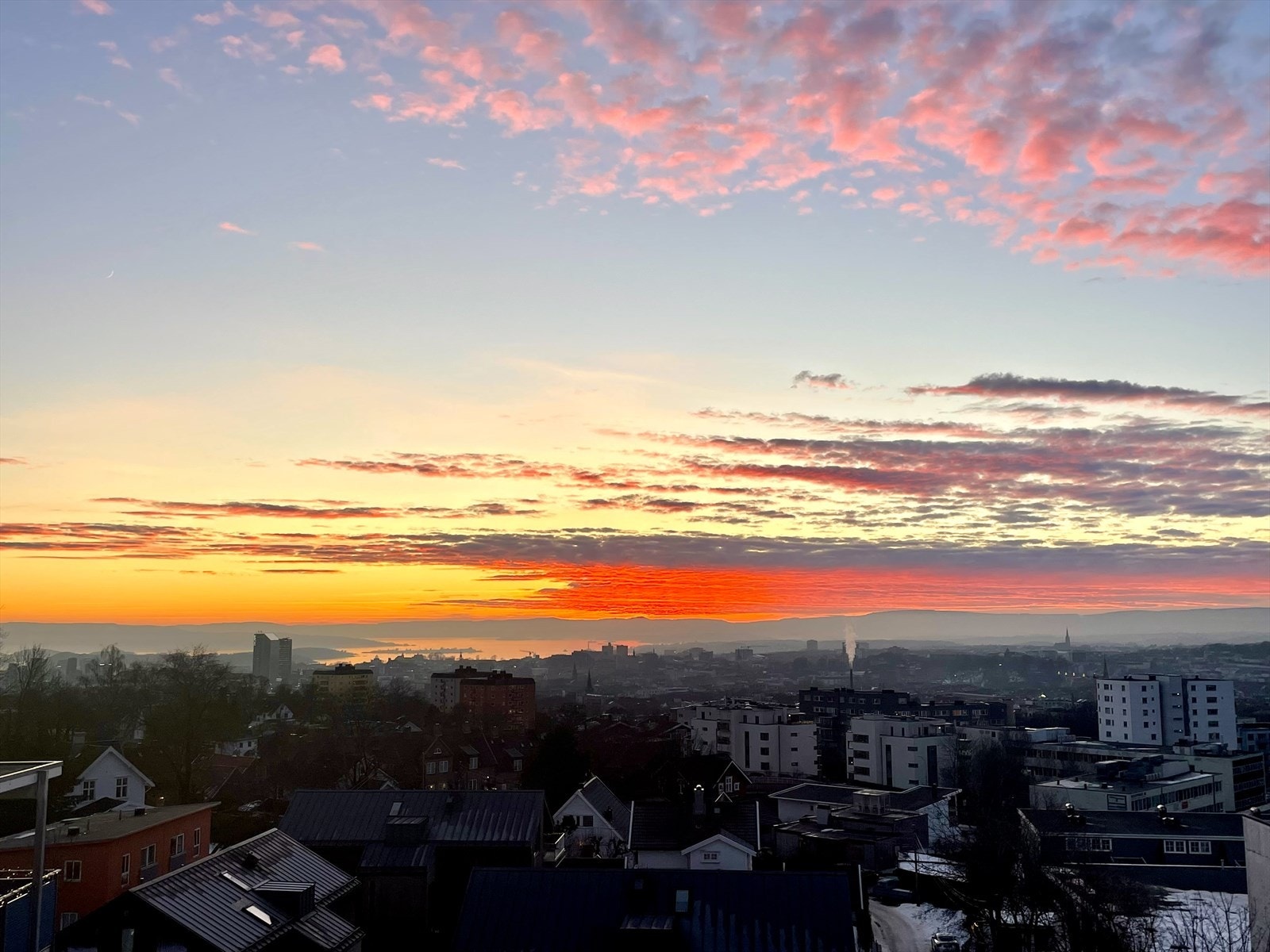 En fantastisk utsikt over byen, hvor fargene på himmelen skaper en rolig og magisk stemning Galleribilde