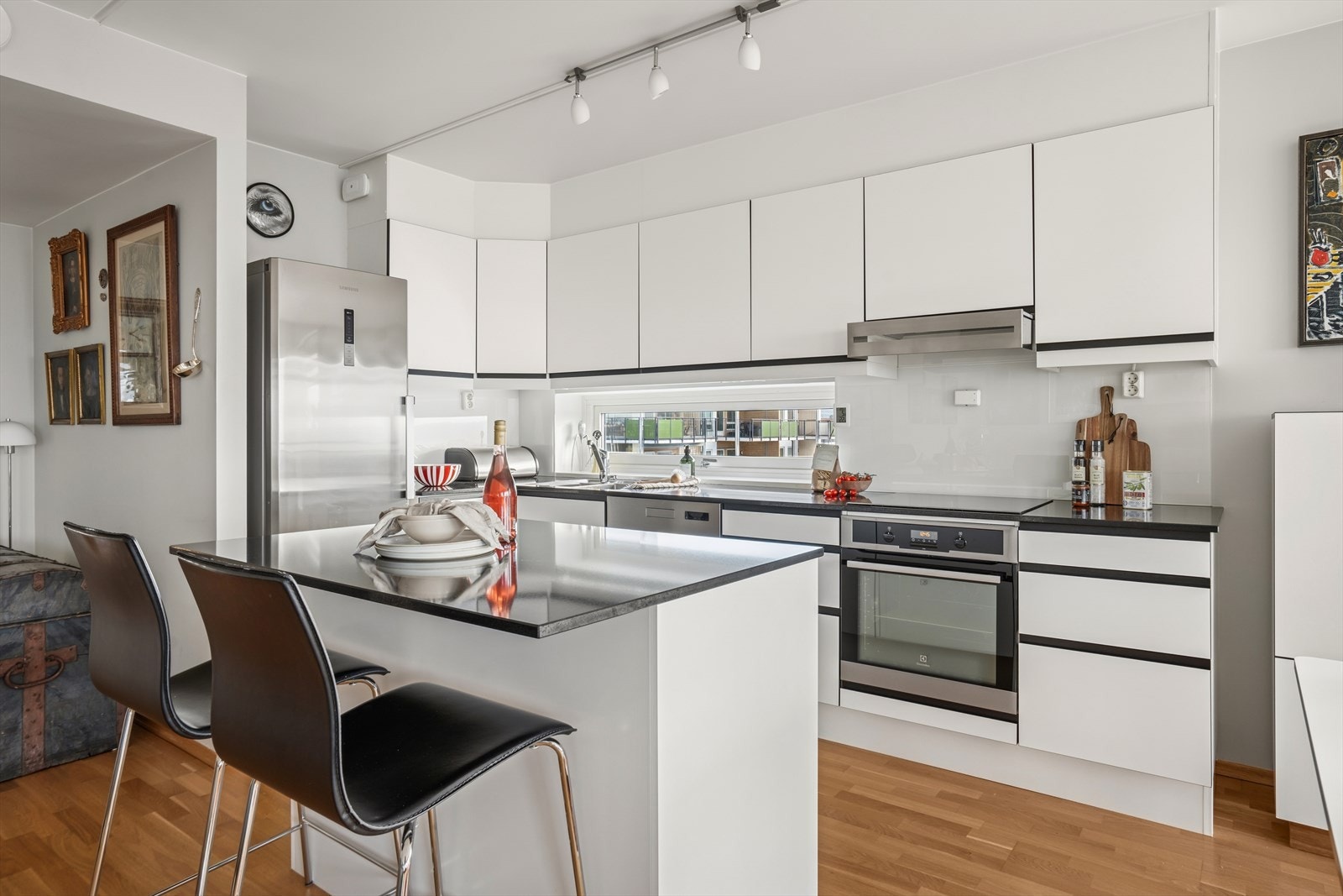 Kjøkkenet har et moderne design, med glatte folierte fronter, kompositt benkeplate og en praktisk kjøkkenøy. Galleribilde