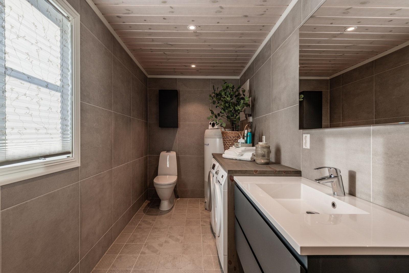 Bad to har også fliser på gulv og vegger, i tillegg har badet opplegg for vaskemaskin. Galleribilde