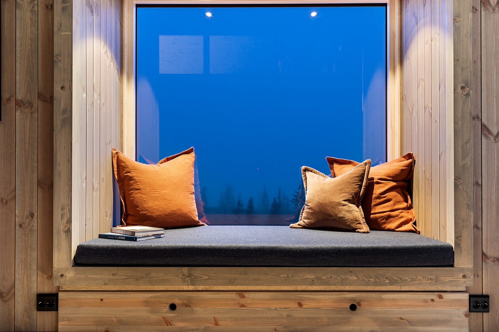 Blåtimen. Fasadeelement med sittebenk. Pute med trekk fra Gudbrrandsdalen Uldvarefabrik. Stor skuff under benk. Galleribilde