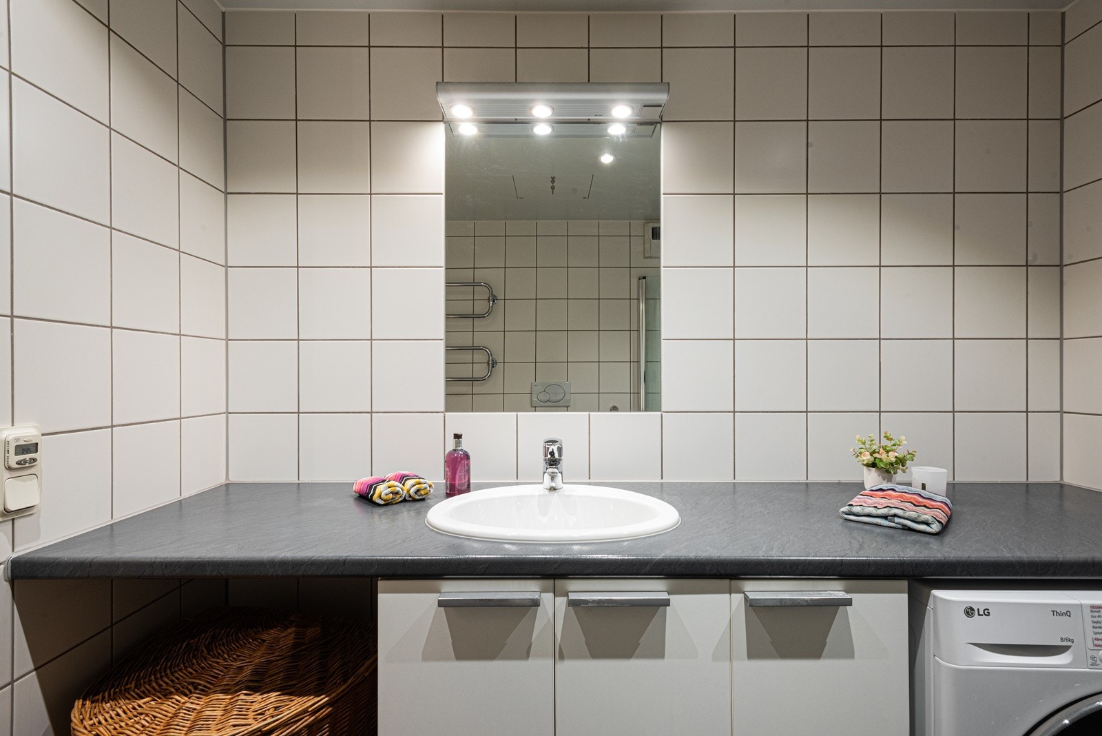 Badet er innredet med servant, servantskap og det er opplegg for vaskemaskin Galleribilde