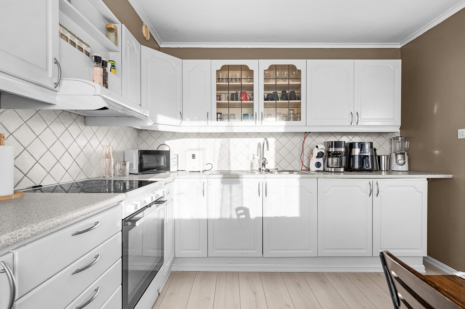 Kjøkkenet har godt med benkeplass og oppbevaring i skap Galleribilde