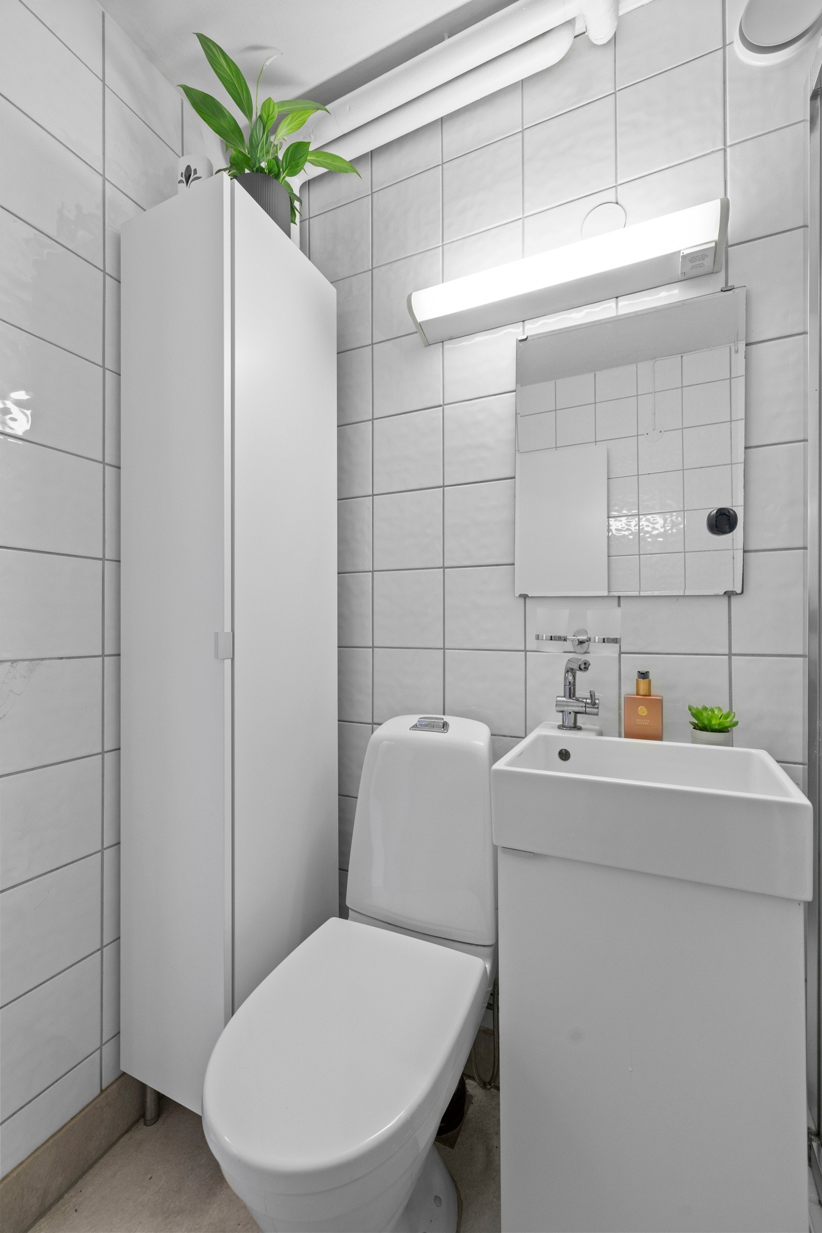 Den øvrige innredningen består av et hvitt servantskap, et matchende høyskap og et speil med belysning over servanten Galleribilde