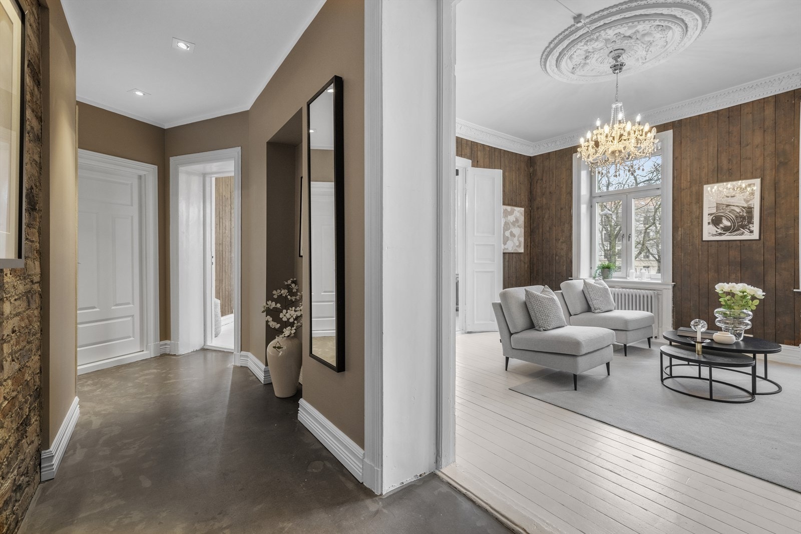 Entréen har en kombinasjon av teglstein og malte gipsplater sammen med downlights i taket, som gir et moderne uttrykk som står i fin kontrast til de mer klassiske detaljene i resten av boligen Galleribilde