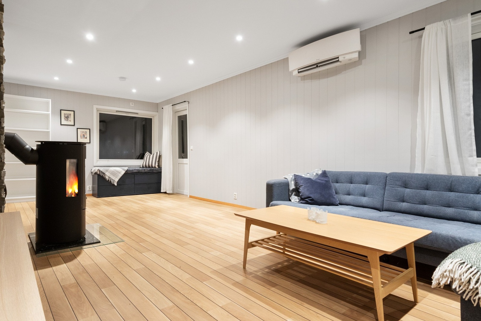 Sentralt i rommet er det en rentbrennende peisovn, og stuen har i tillegg en luft-til-luft varmepumpe som sørger for jevn temperatur gjennom hele året. Galleribilde