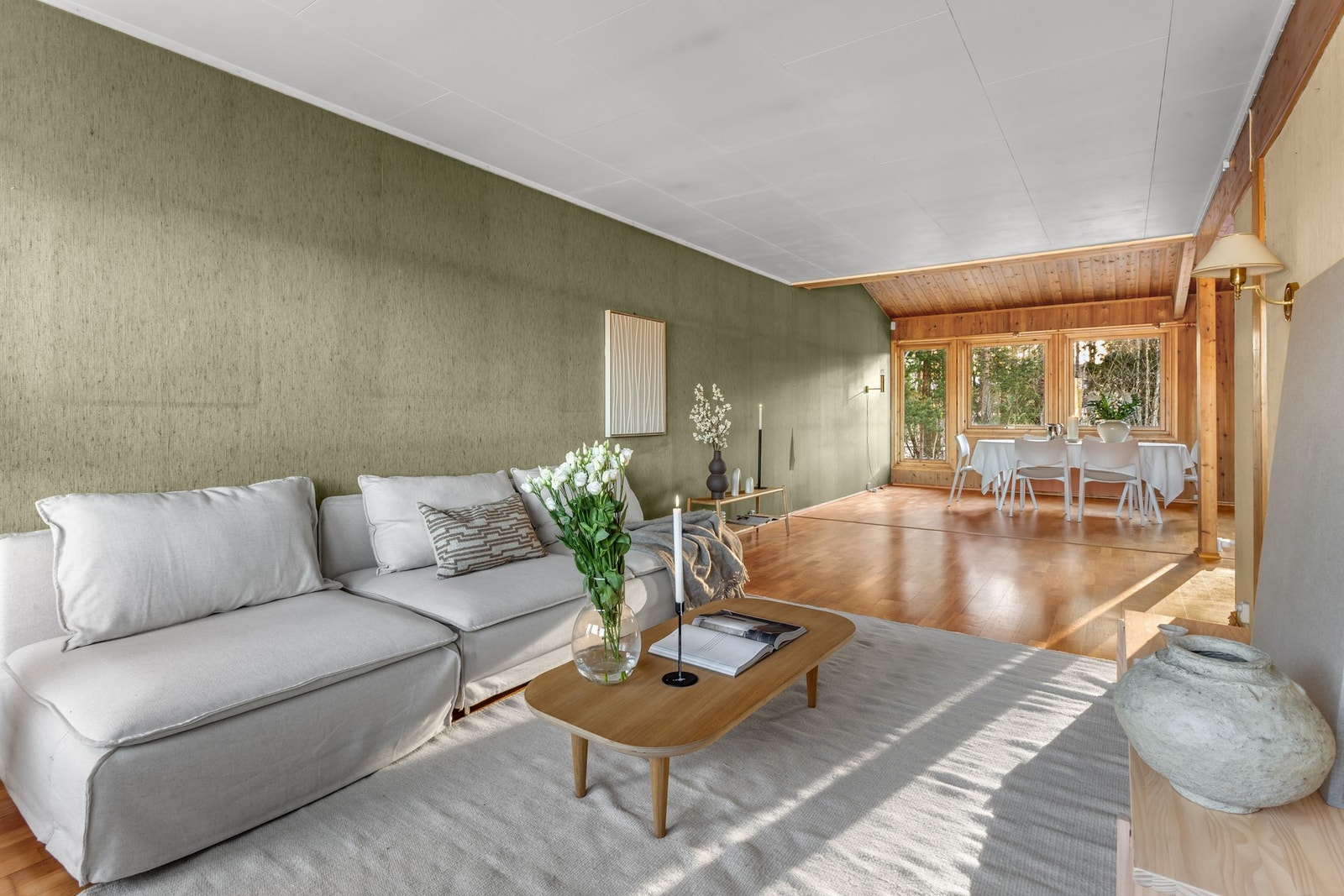 Spiseplassen ligger i forlengelse av stuen, med utsikt til skogholt. Galleribilde