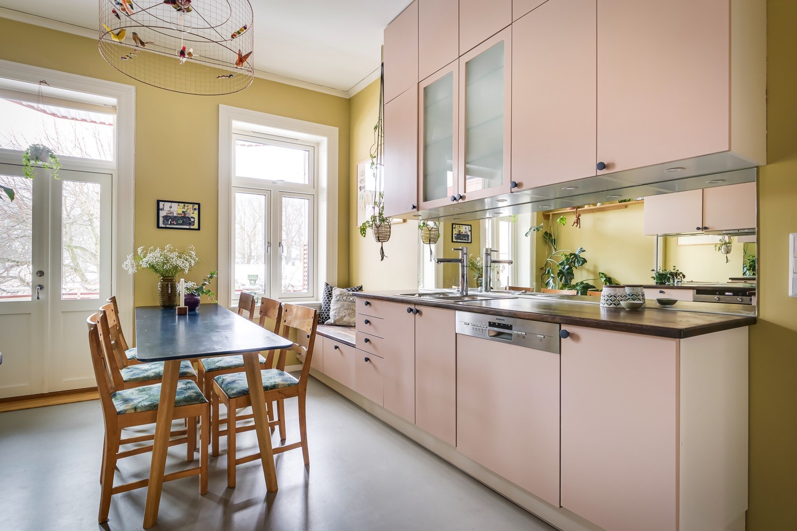 Rikelig med skap- og benkeplass i kjøkkeninnredning med lyse, glatte fronter og tre benkeplate. Galleribilde