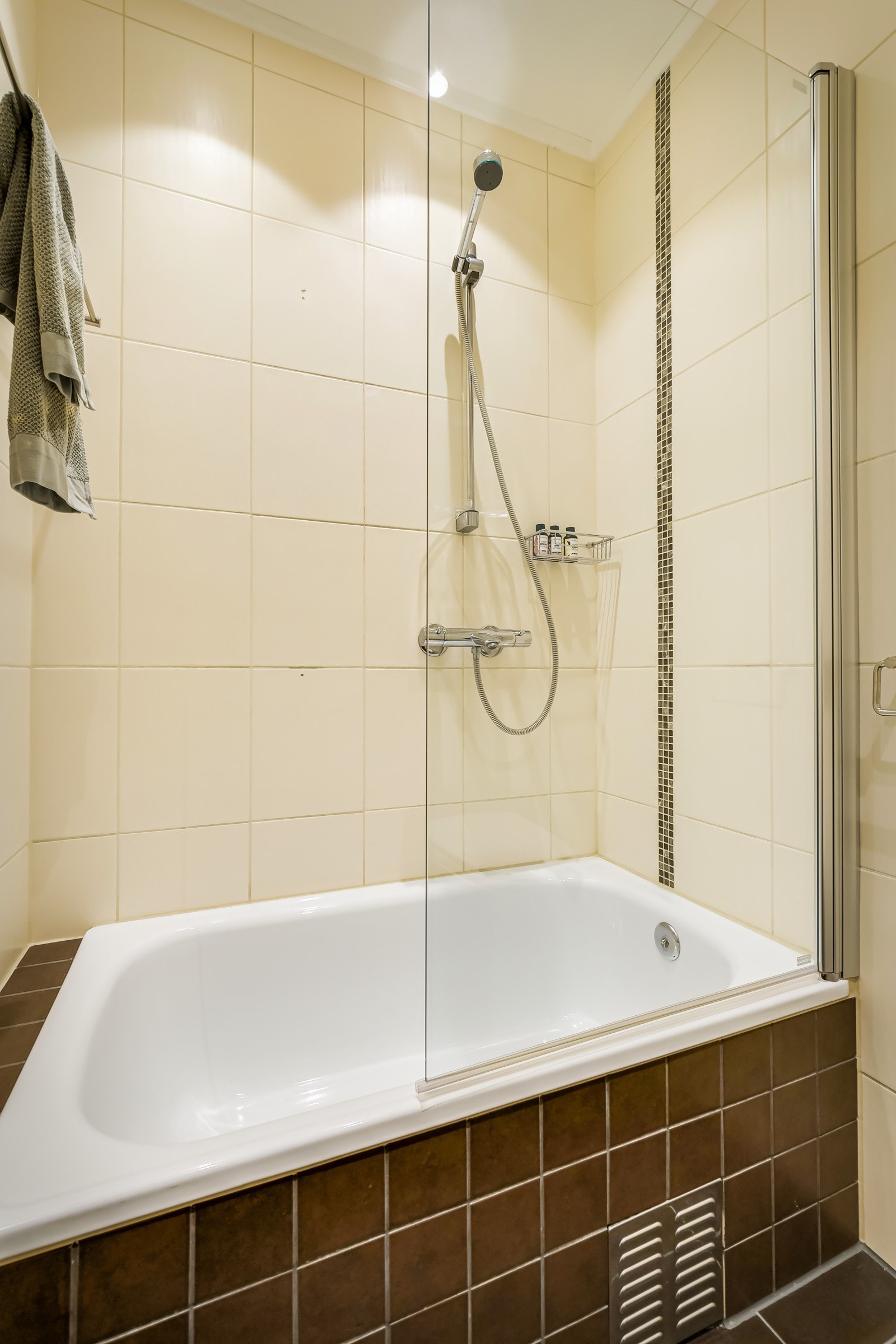 Baderommet er utstyrt med servantskap, speilskap med belysning, innmurt badekar med glassvegg og hånddusj, samt vegghengt toalett. Galleribilde