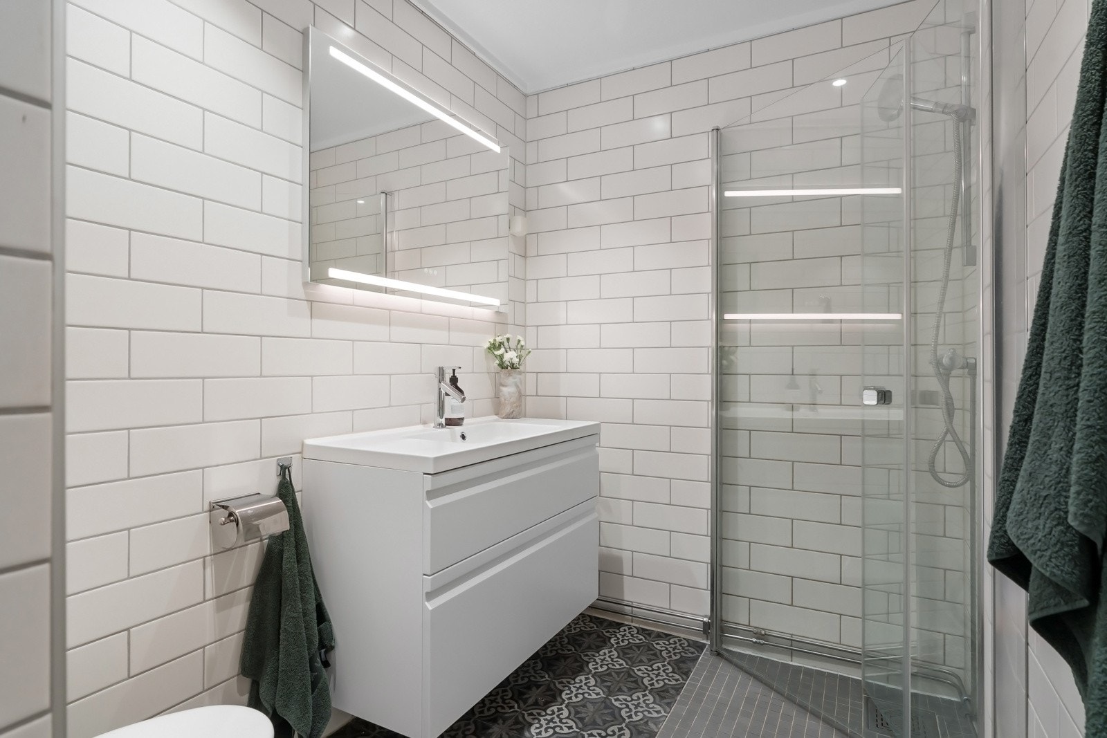 Leiligheten har et lyst flislagt bad, med moderne innredning fra 2020 Galleribilde