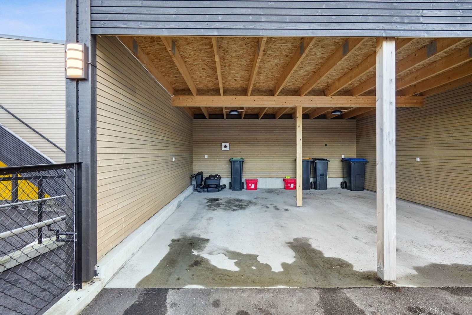 Parkering gjøres i tilhørende carport - her er det montert el-bil lader. Det er også biloppstillingsplass, samt gjesteparkering på tomten. Galleribilde