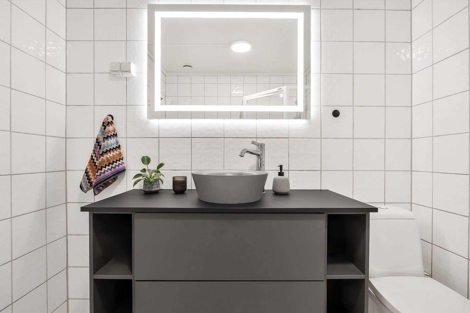 Moderne baderom med stilren servant og speil med belysning. Galleribilde