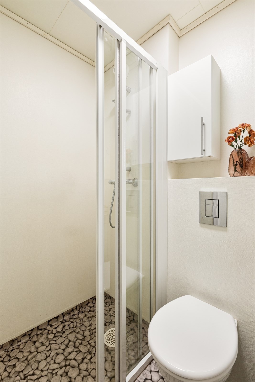 Bad i 2. etasje er innredet med vask i seksjon, vegghengt toalett og dusjhjørne. Det er behov for totalrenovering av badet. Galleribilde