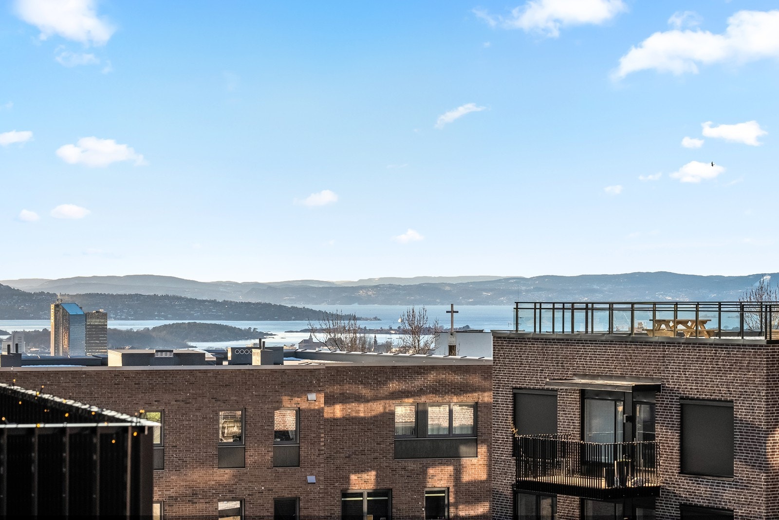 Dette er en splitter ny og lekker 3-roms selveierleilighet i 5. etasje med en super god beliggenhet med utsikt! Leiligheten ligger både vestvendt og rolig til. I tillegg er det godt med luft mellom blokkene. (På dette bildet er utsikten zoomet). Galleribilde