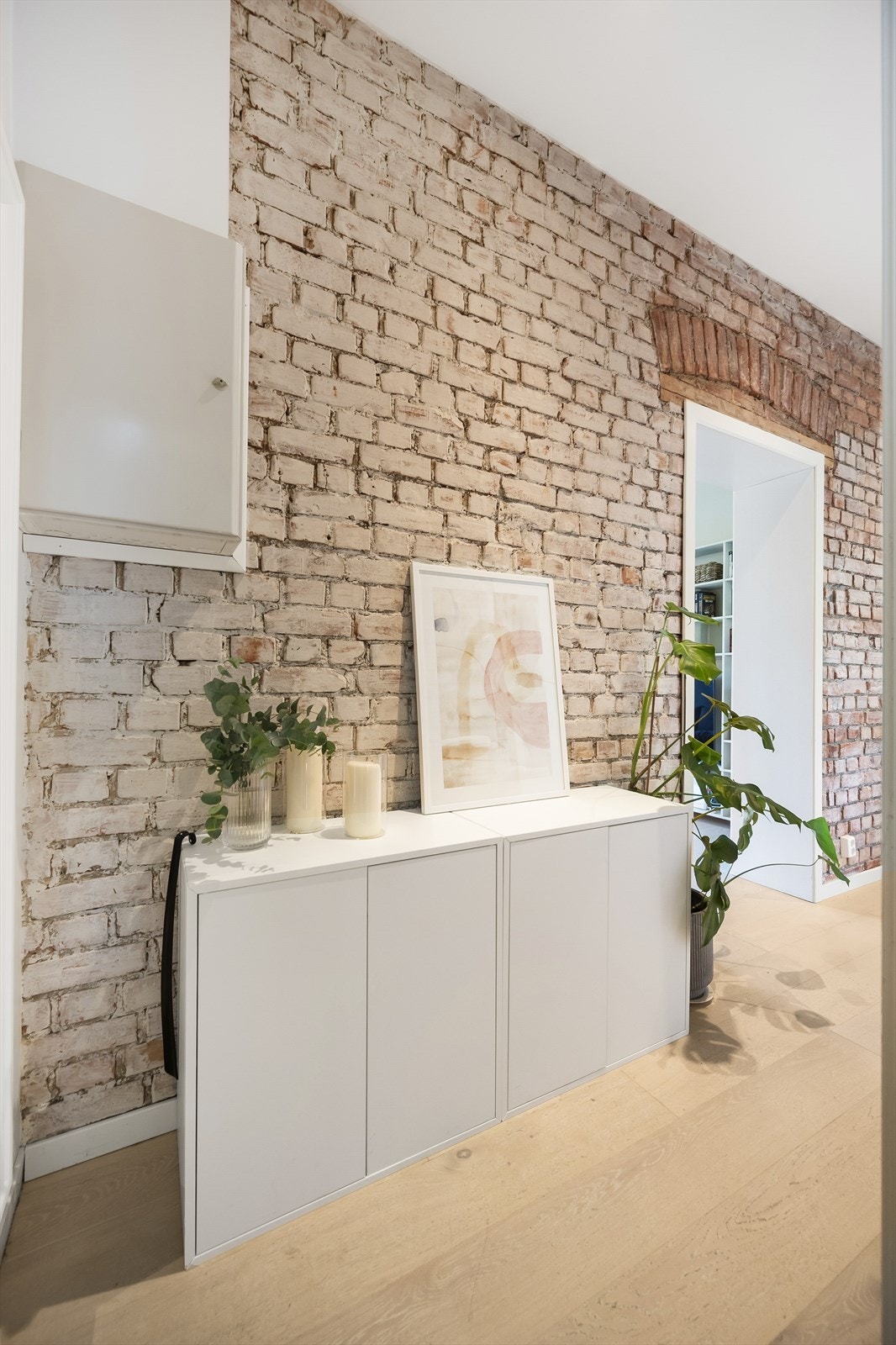 Leiligheten byr på en innbydende entré som gir et umiddelbart godt førsteinntrykk, med en karakteristisk original teglsteinsvegg som setter en sjarmerende tone for resten av boligen. Galleribilde