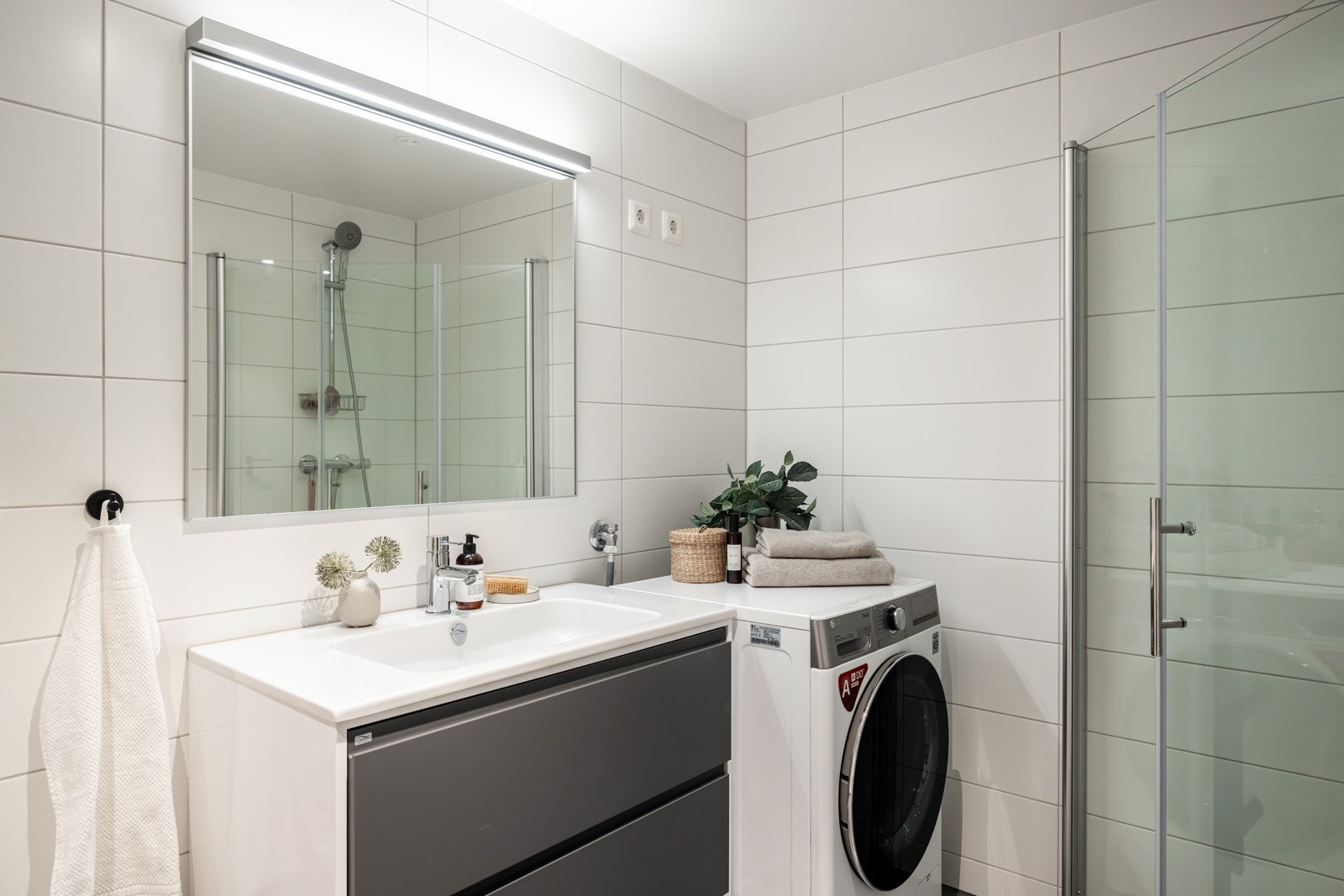 Badet har en tidløs innredning med skuffer for oppbevaring og heldekkende servant. Opplegg for vaskemaskin og stikkontakt for tørketrommel. Galleribilde