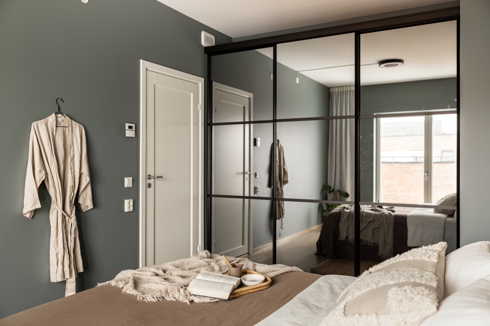 Det er satt opp en stor plasstilpasset skyvedørsgarderobe med speilfronter. Galleribilde