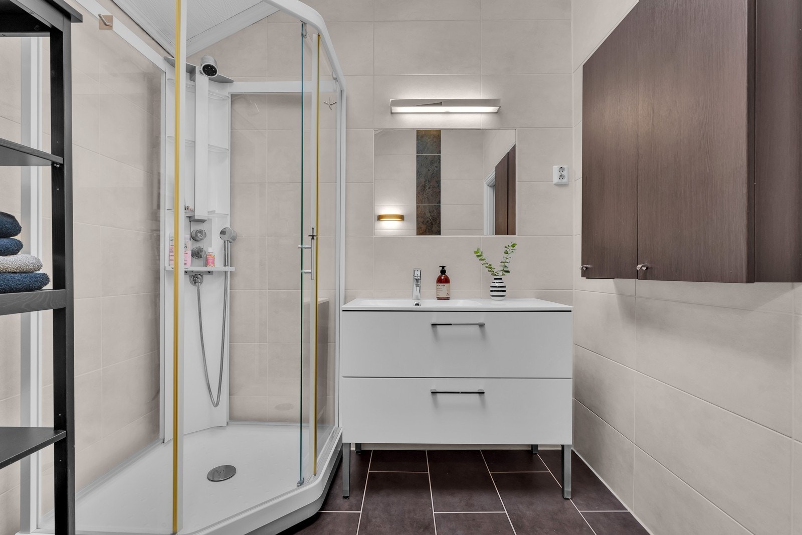 Badet er innredet med nedfelt servant, veggmontert toalett og dusjkabinett. Galleribilde