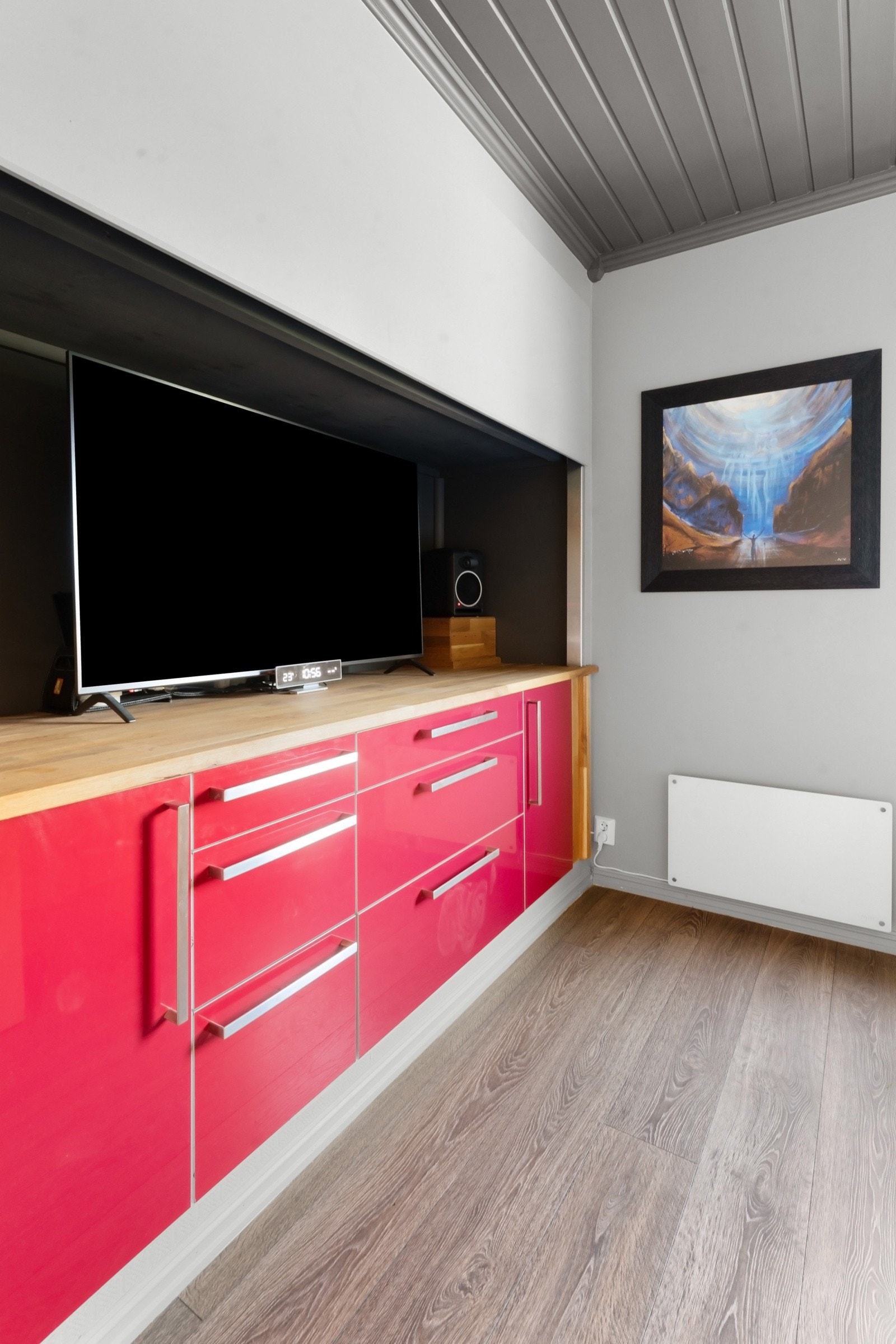 Indre del av rommet har en plassbygd skjenk med røde skuffefronter, benkeplate i heltre og nisje med god plass til flatskjerm. Galleribilde