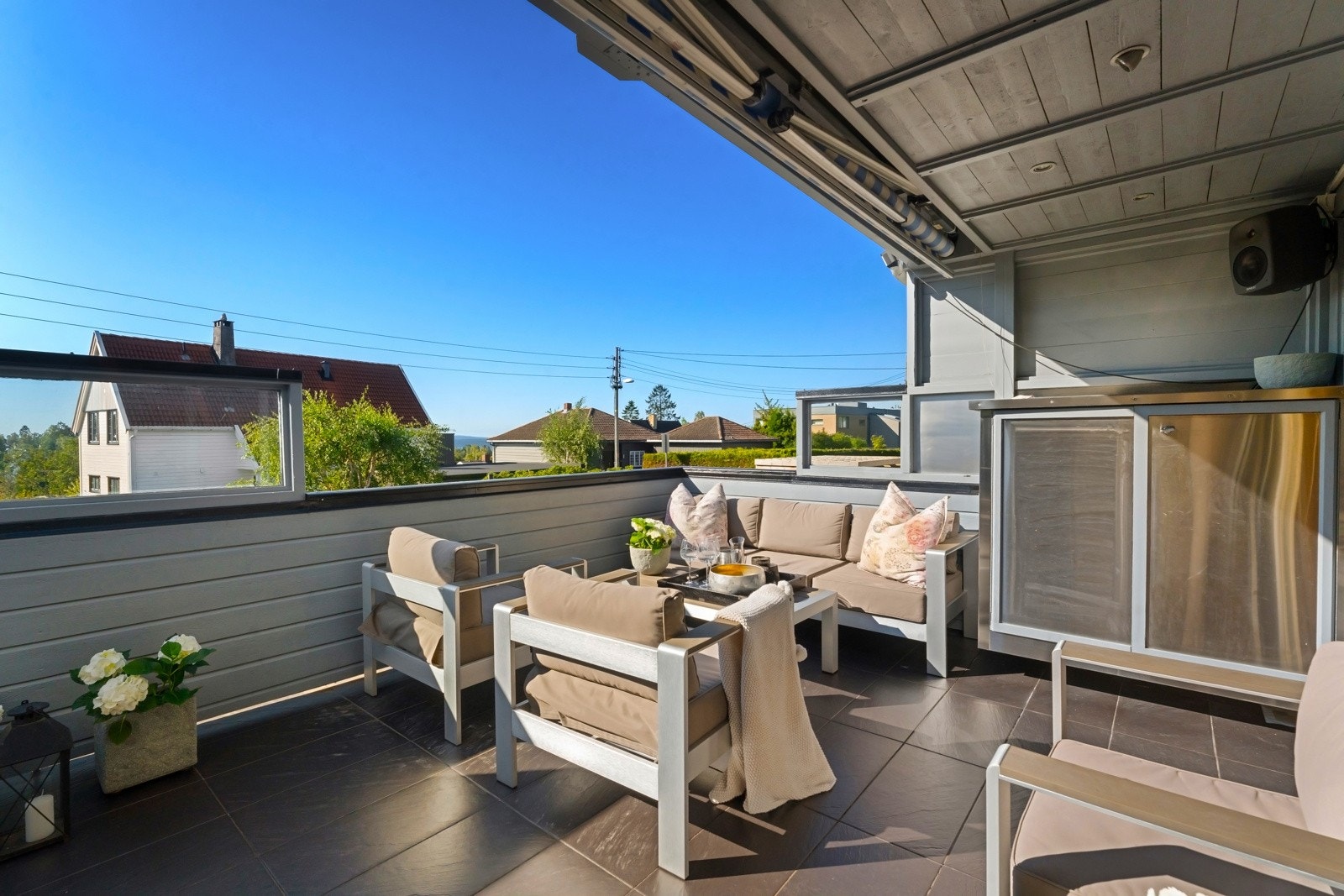 Boligen har to sydvendte terrasser på ca. 19 m² hver, den nederste med utekjøkken og den øverste med utsikt helt til fjorden. Galleribilde