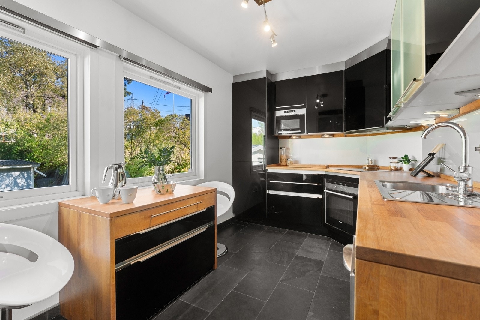 Kjøkkenet ligger i eget rom med nordvendte vinduer, grå fliser på gulvet, lysmalte vegger og listefri himling. Innredningen er fra tyske Rotpunkt og har benkeplate i heltre. Galleribilde