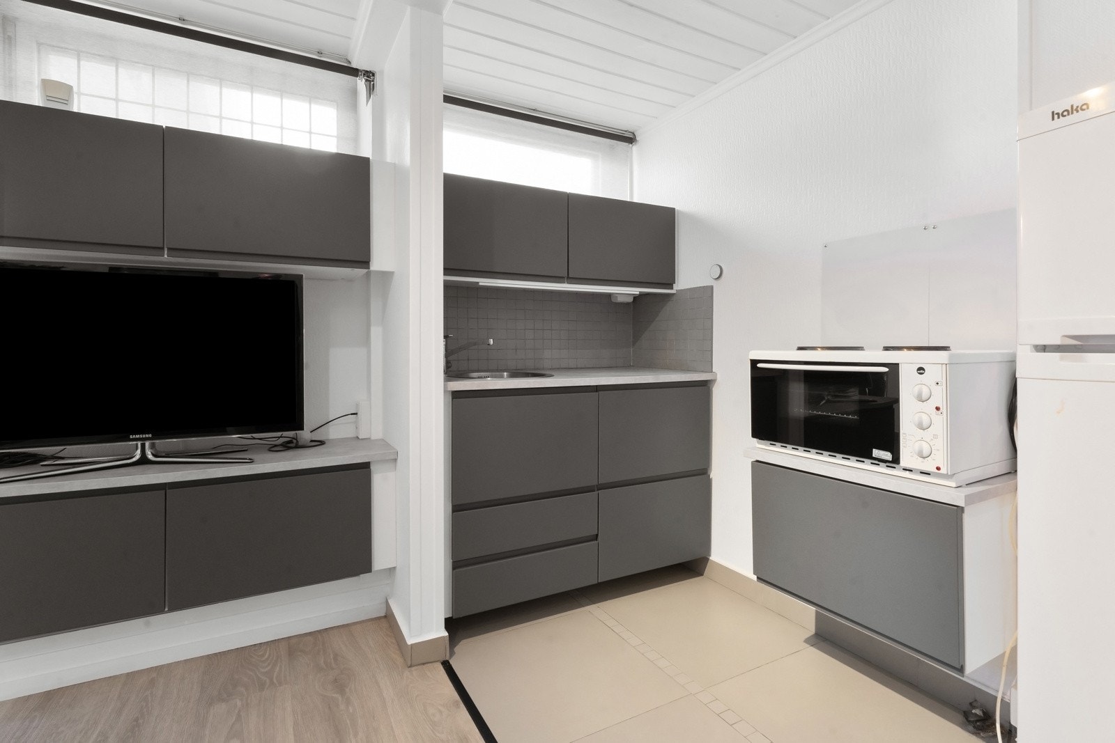 Stuen har lysmalte vegger, hvitmalt panelhimling og pent gulv i enstavs laminat. Kjøkkeninnredningen er plassert langs innerste del. Galleribilde