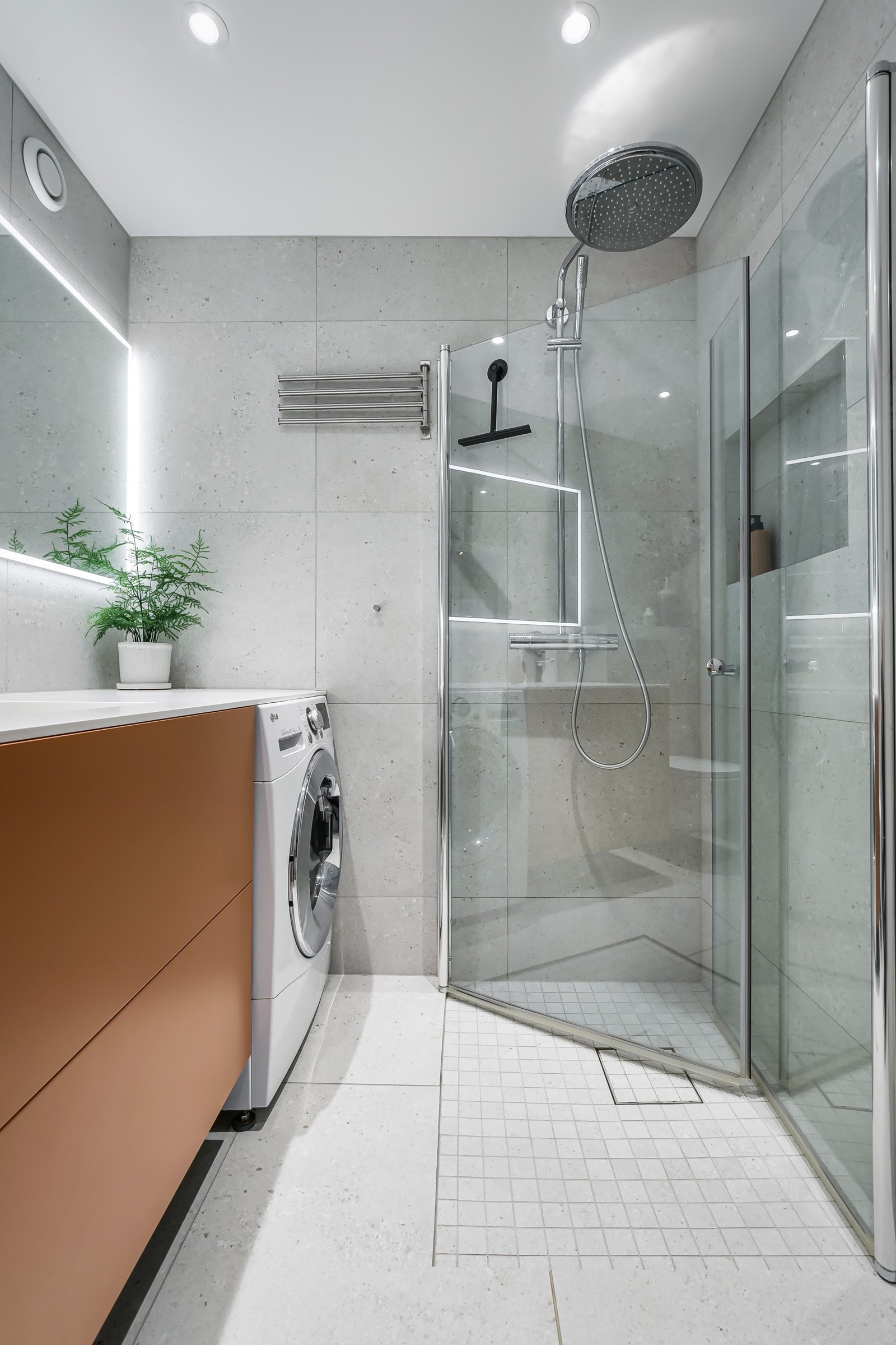 Baderommet er også utstyrt med dusjhjørne med innfellbare glassdører og ett-greps armatur med dusjhode i tillegg til regnfallsdusj samt vegghengt toalett. Galleribilde