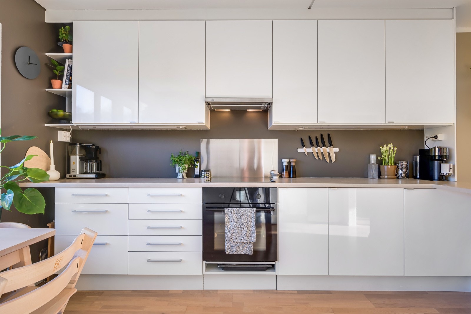 Innredningen har hvite glatte fronter og heltre benkeplate med stor kompositt opppvaskum. Kullfiltervifte. Galleribilde