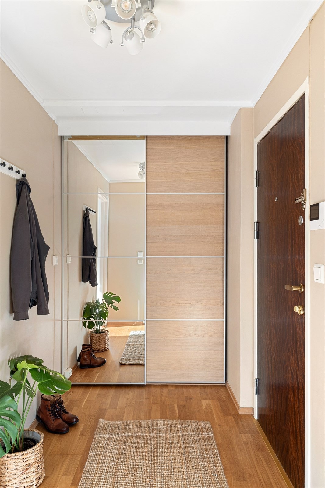 Lys og innbydende entré med skyvedørsgarderobe og veggmonterte knagger, som gir praktisk og ryddig oppbevaring av yttertøy og sko. Galleribilde