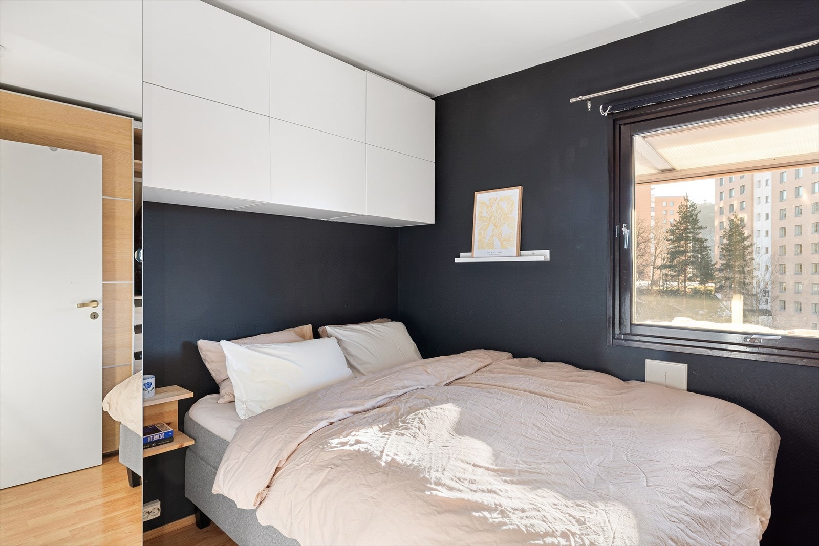 Hyggelig soverom med laminatgulv og mørke vegger som gir en lun og innbydende atmosfære. Galleribilde