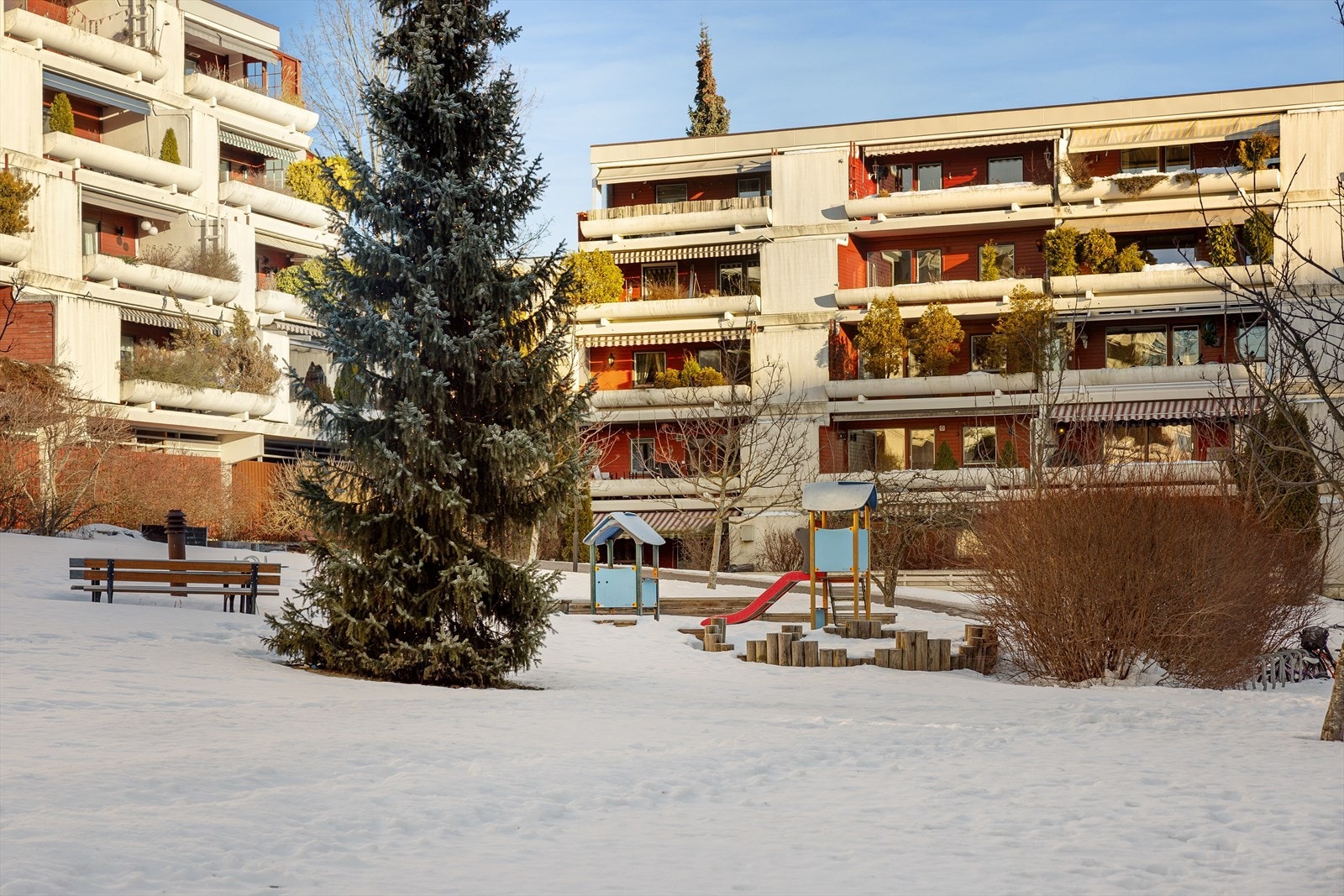 Hyggelig felles uteområde i borettslaget med grøntarealer, sitteplasser og lekeplass, perfekt for både avslapning og sosialt samvær. Galleribilde