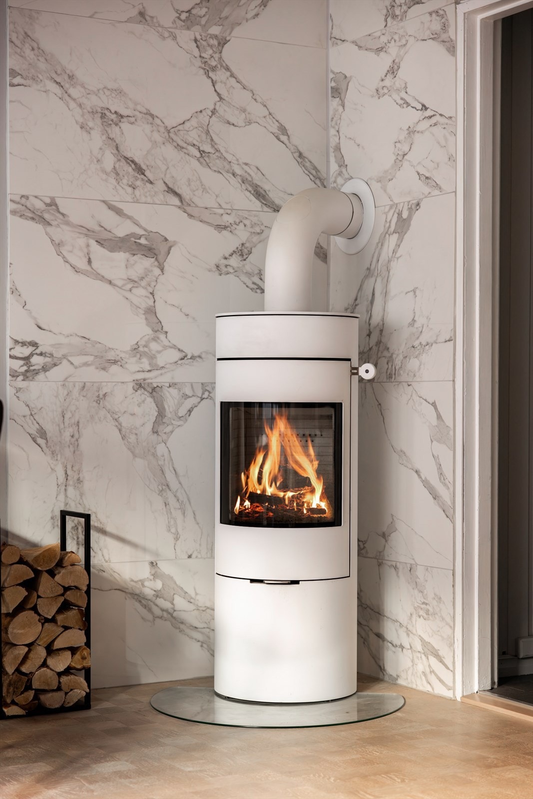 Stuen har en nydelig peis fra 2018, som både gir effektiv varme og et estetisk løft. Peisen står mot en flislagt vegg i marmordesign. Galleribilde