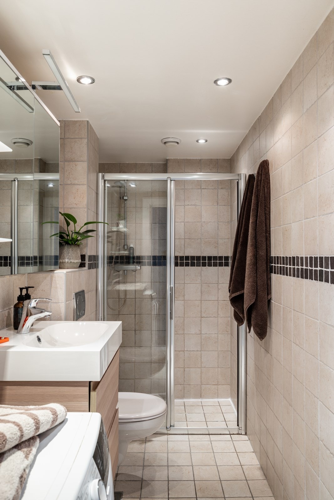 Innredningen består blant annet av en nedsenket dusjnisje med skyvedør i glass, vegghengt toalett og servant med ett-greps blandebatteri. Galleribilde