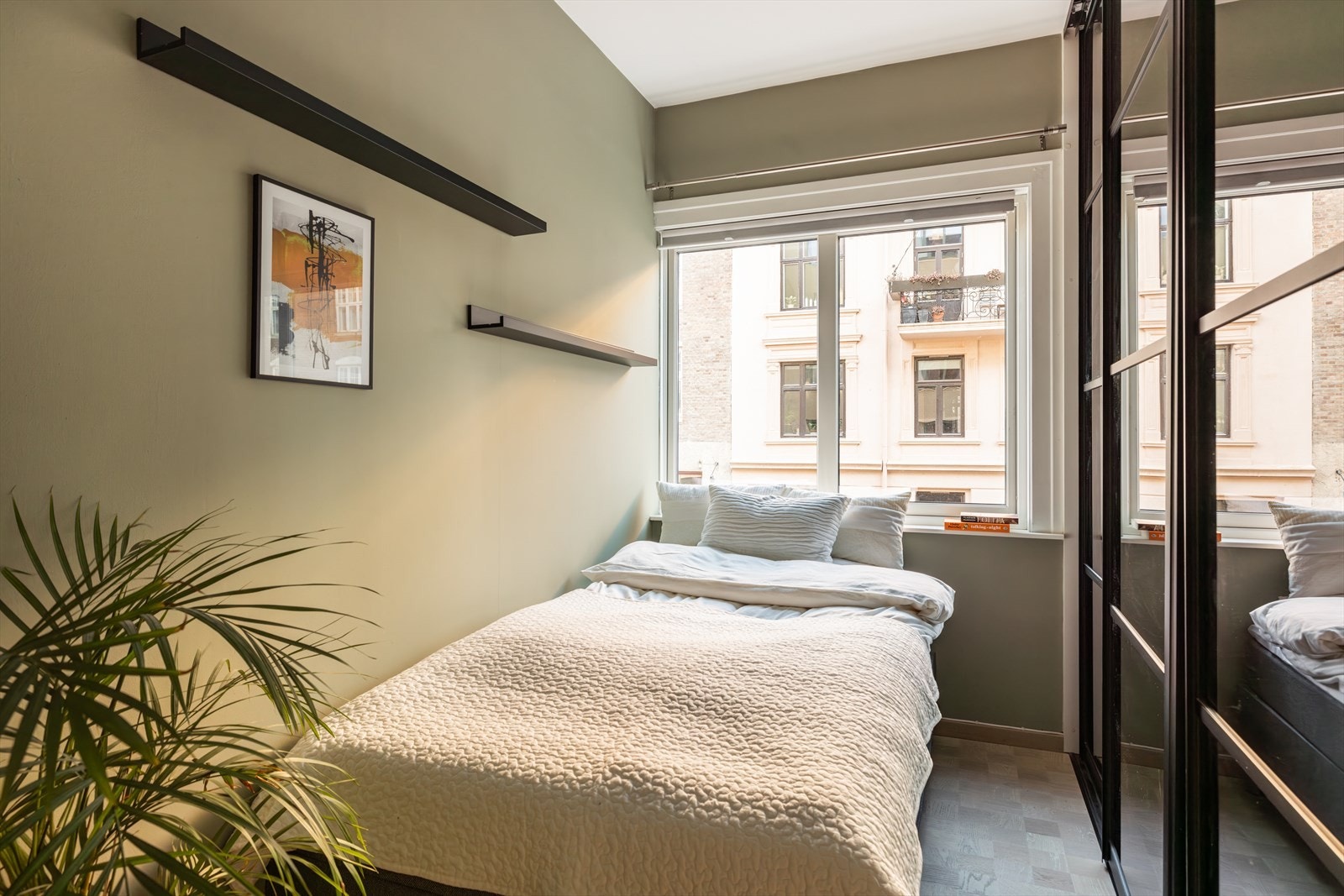 Lyst og innbydende soverom 2 med samme elegante parkett i rutemønster. Galleribilde