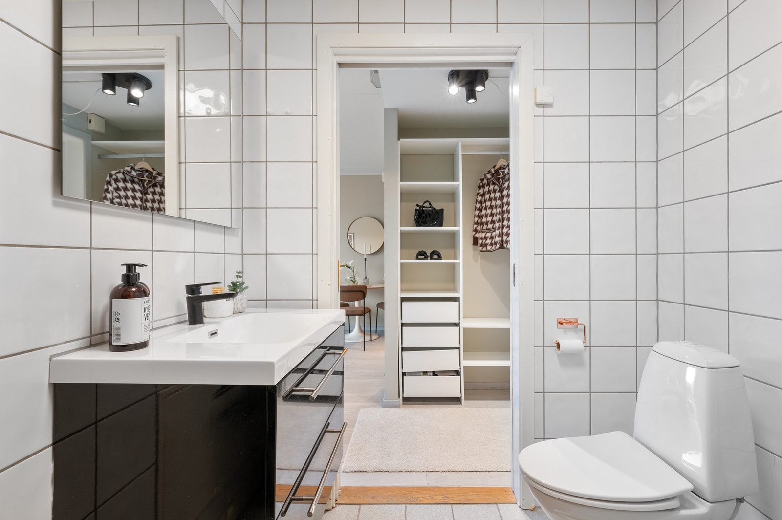 Badet inneholder dusjhjørne, gulvmontert wc, servant med underskap, speil og opplegg for vaskemaskin Galleribilde