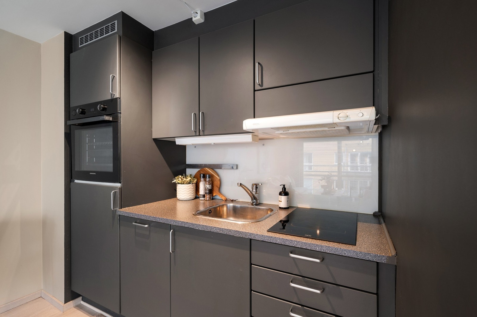 Flott kjøkken med integrerte hvitevarer som platetopp, stekeovn, oppvaskmaskin og kjøleskap. Galleribilde