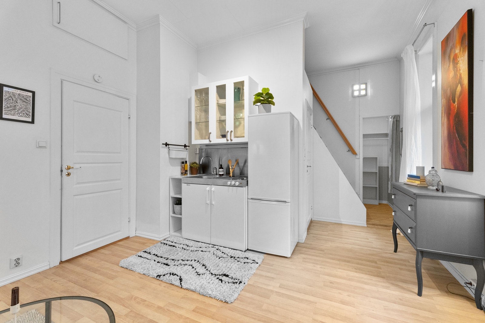 Kjøkkenet har innredning med glatte fronter, servant og benkeplate, samt overskap med glassfronter. Galleribilde