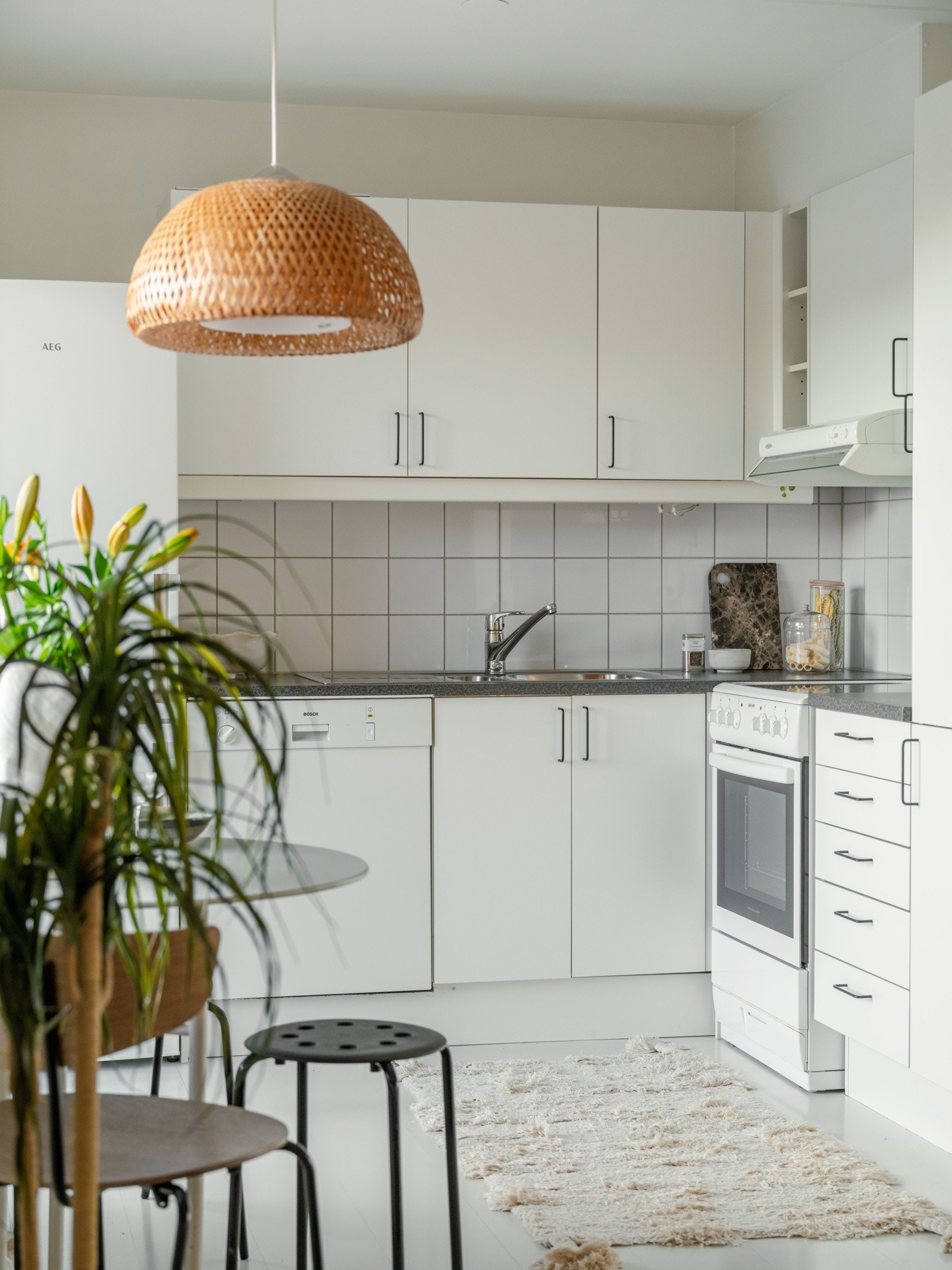 Lys kjøkkeninnredning med slette fronter og laminat benkeplate. Kjøle- og fryseskap, oppvaskmaskin og komfyr følger med. Galleribilde