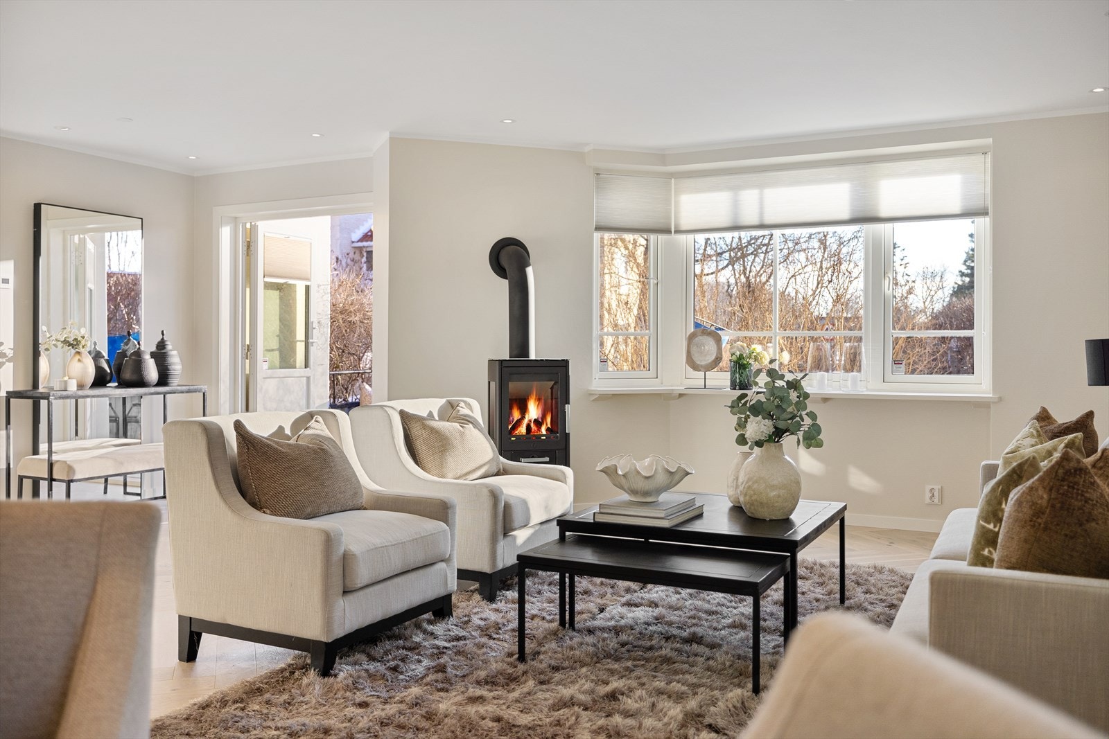 Lys og delikat stue med ny peisovn og utgang til balkong Galleribilde