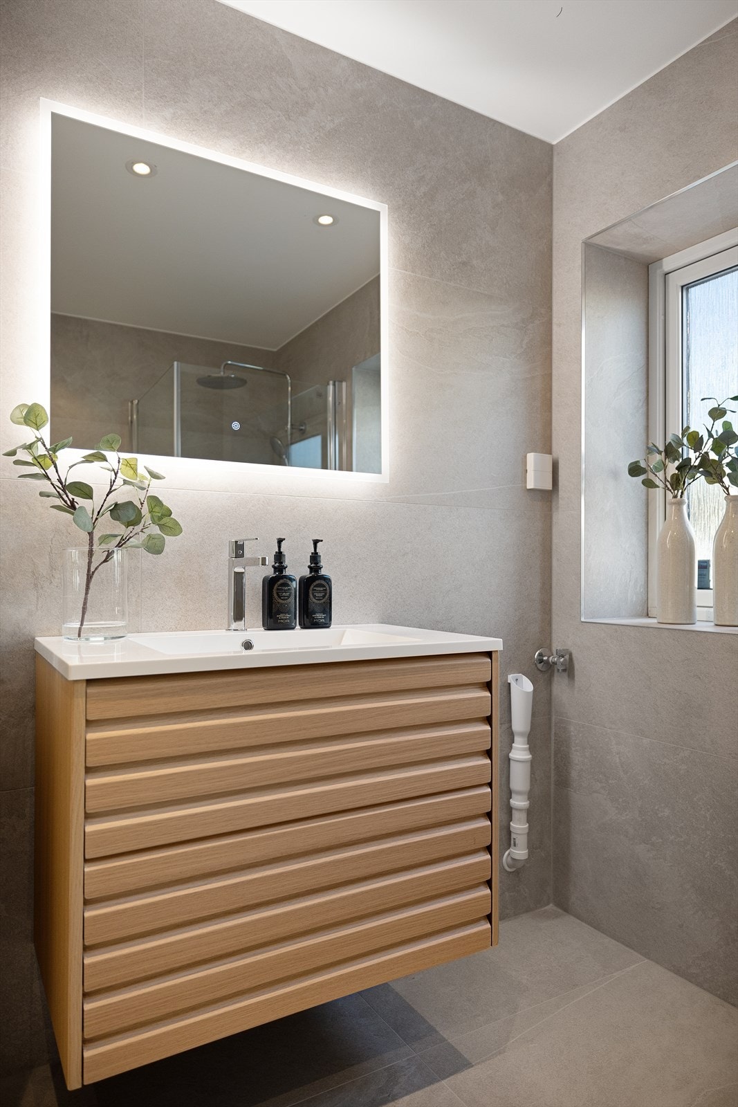 Badet er romslig og har et lekkert interiør med pene overflater. Vindu fra 2010 og gode lysforhold Galleribilde