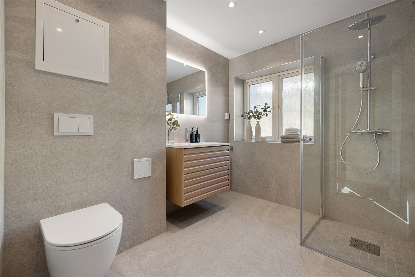 Nyoppusset bad med varmekabler i gulv, downlights i himling og opplegg for vaskemaskin Galleribilde