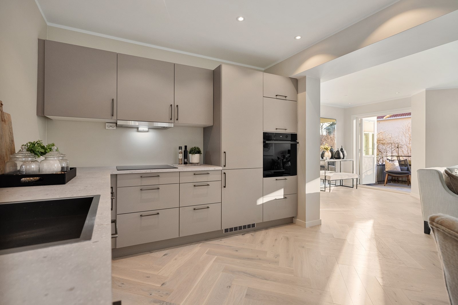 Kjøkkenet ligger i åpen løsning mot stuen og sammen utgjør de et luftig og fint allrom Galleribilde