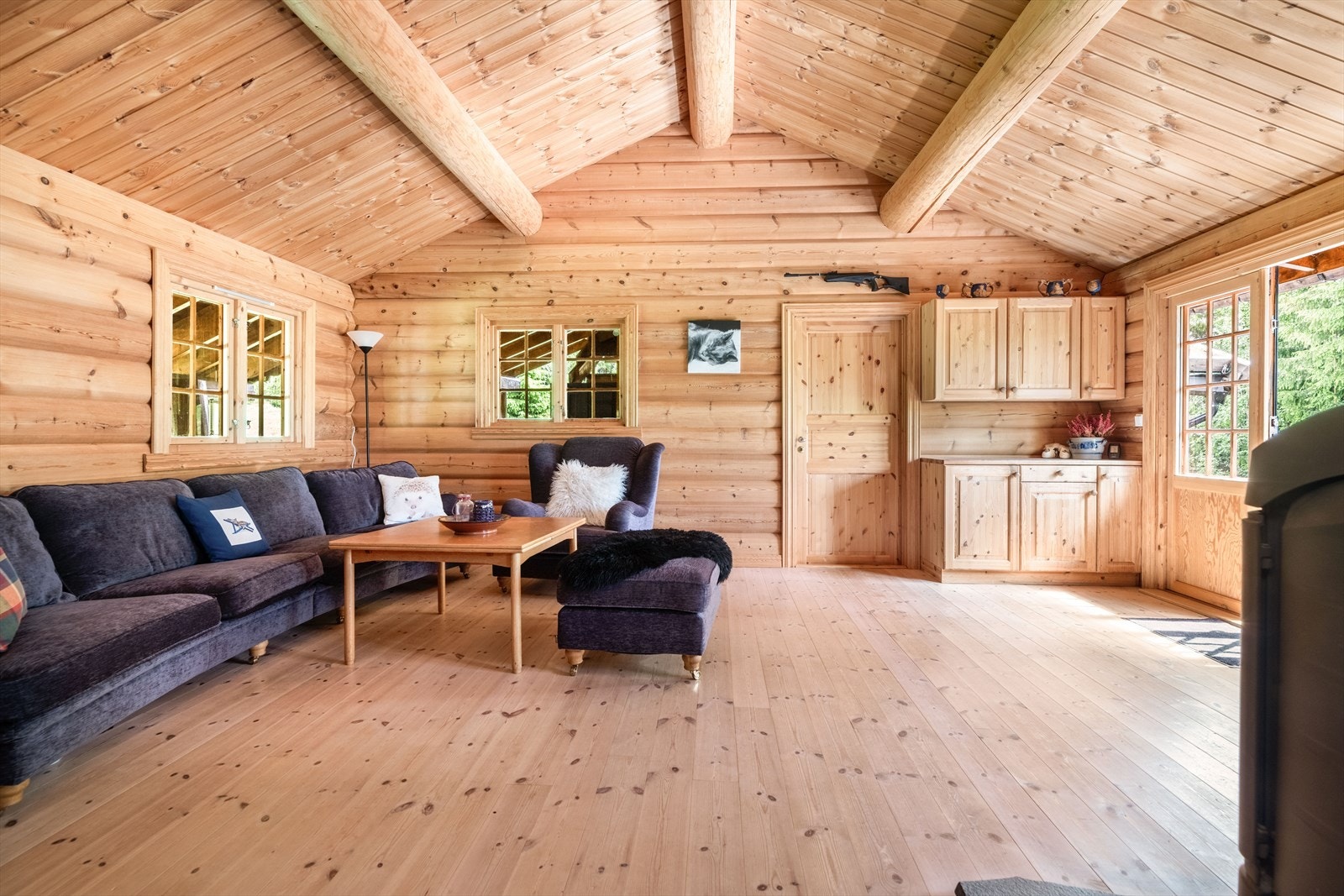 I stua gir den gode takhøyden en fin romfølelse, og det er her plass til både sofagruppe og annen møblering. Det er fra stuen utgang til de sydvendte terrasseområdene som går rundt store deler av hytta. Galleribilde