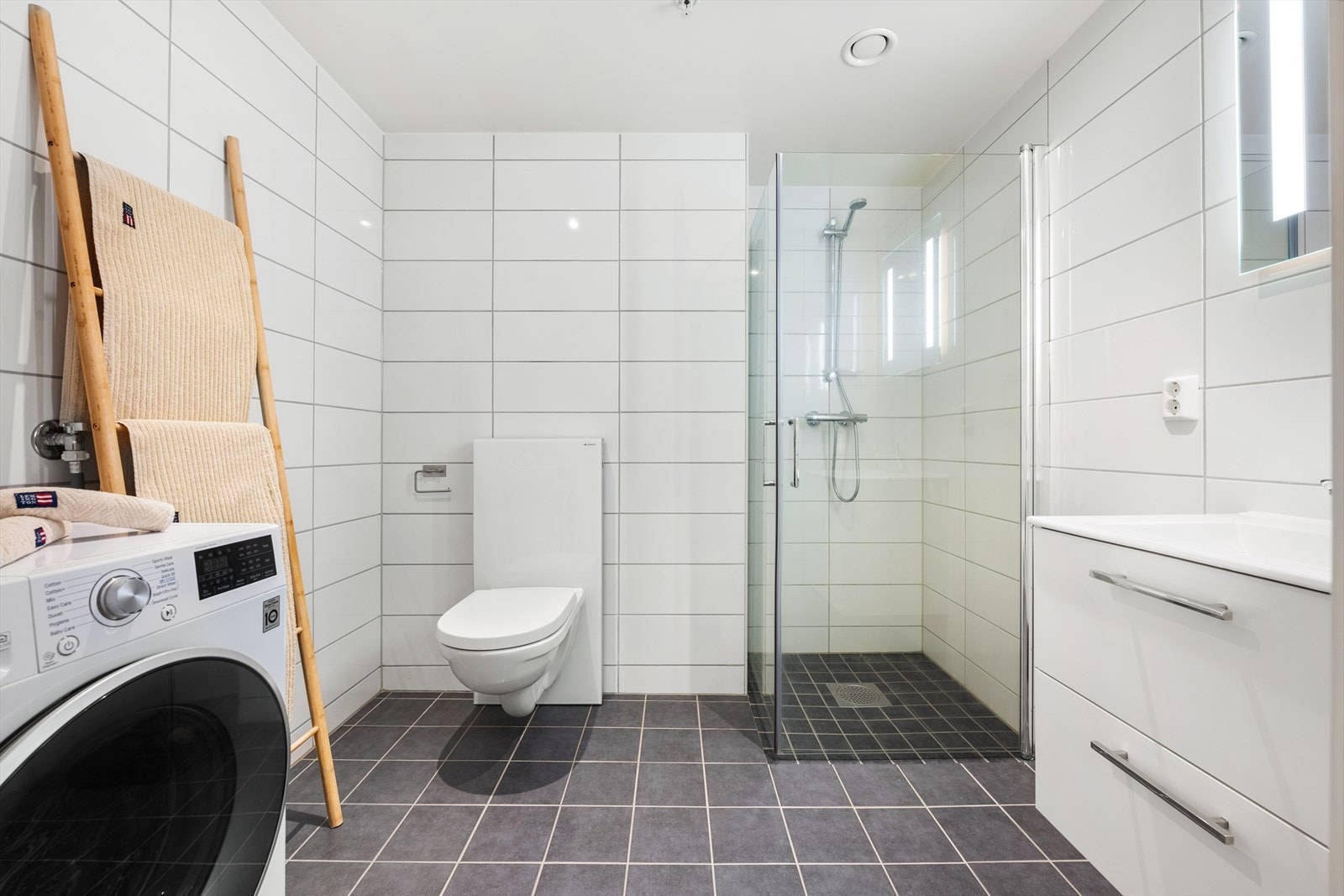 Romslig bad med fliser på vegger og gulv, varme i gulv. Malt tak med nedfelte downlights. Galleribilde