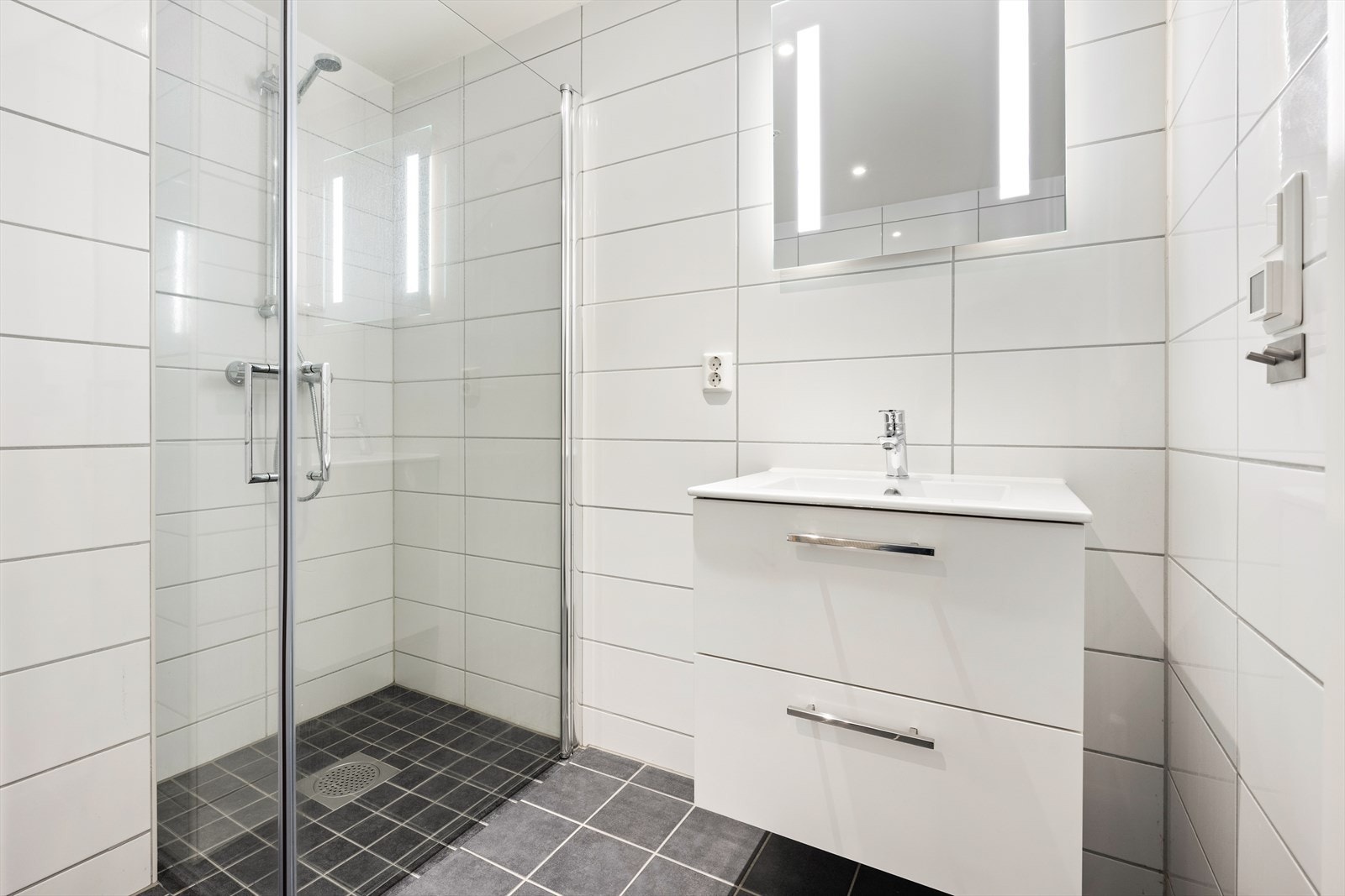 Badet har innredning med nedfelt servant, veggmontert toalett, dusjvegger/hjørne og opplegg for vaskemaskin. Balansert ventilasjon. Galleribilde