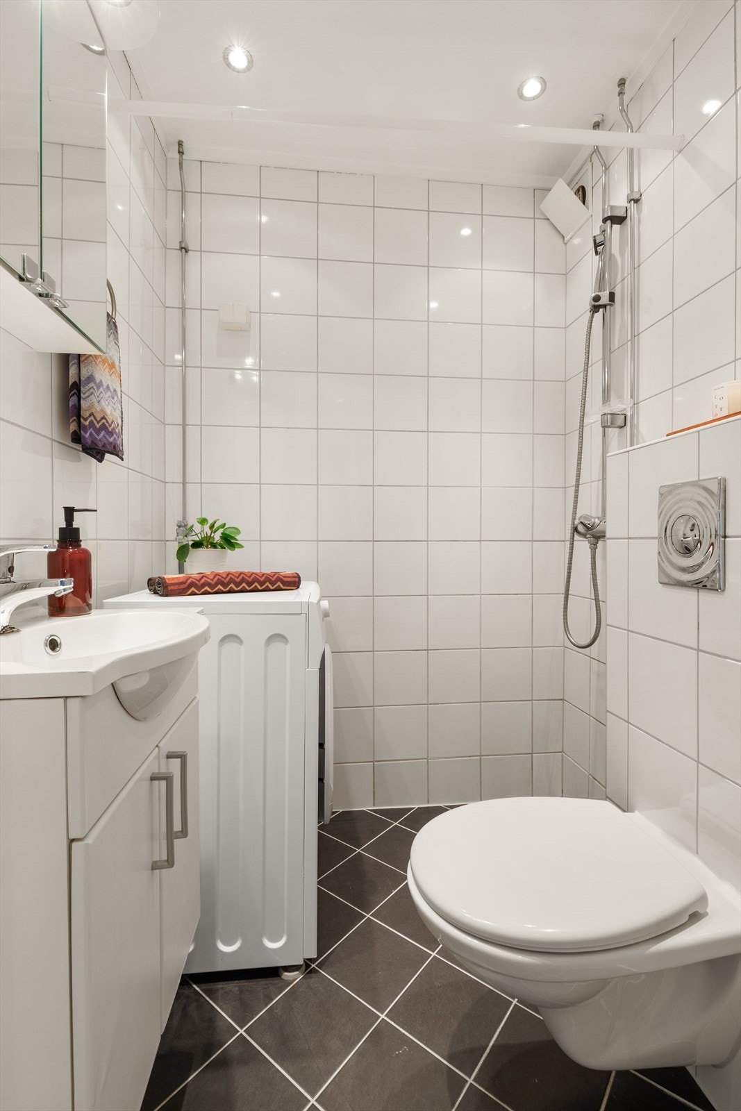 Innredningen består av vegghengt toalett, vegghengt servant med skap og dusjhjørne. Opplegg for vaskemaskin. Galleribilde