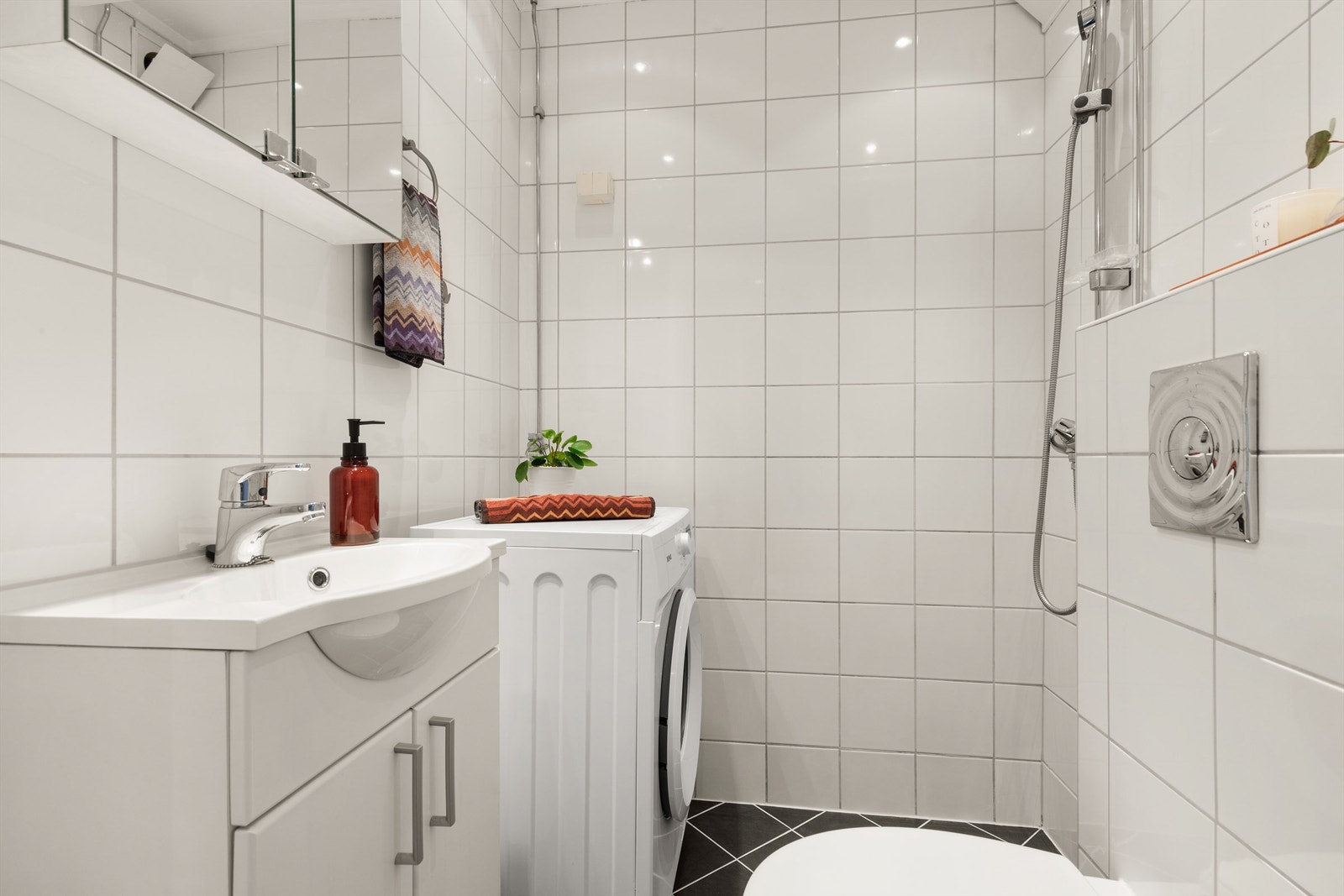 Lyst, flislagt bad med downlights i himling og gulvvarme. Badet ble oppusset i regi av borettslaget i ca. 2008. Galleribilde