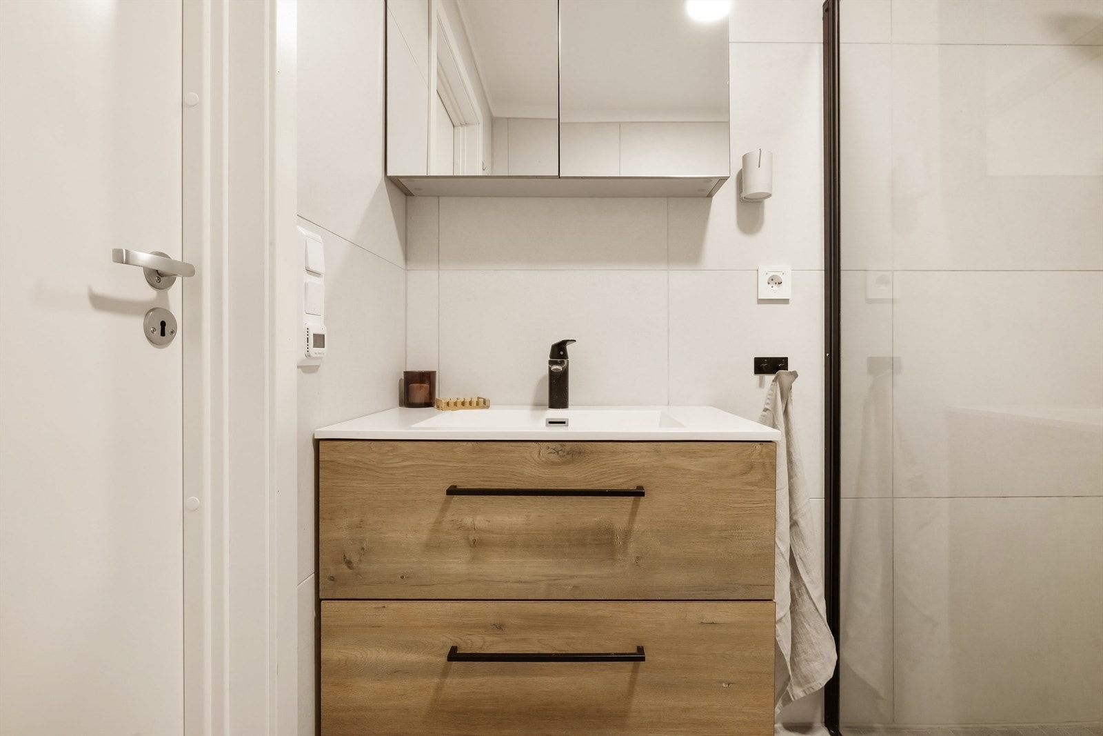 Flott baderomsmøblement med helstøpt servant og speil med oppbevaringsplass i skap. Galleribilde