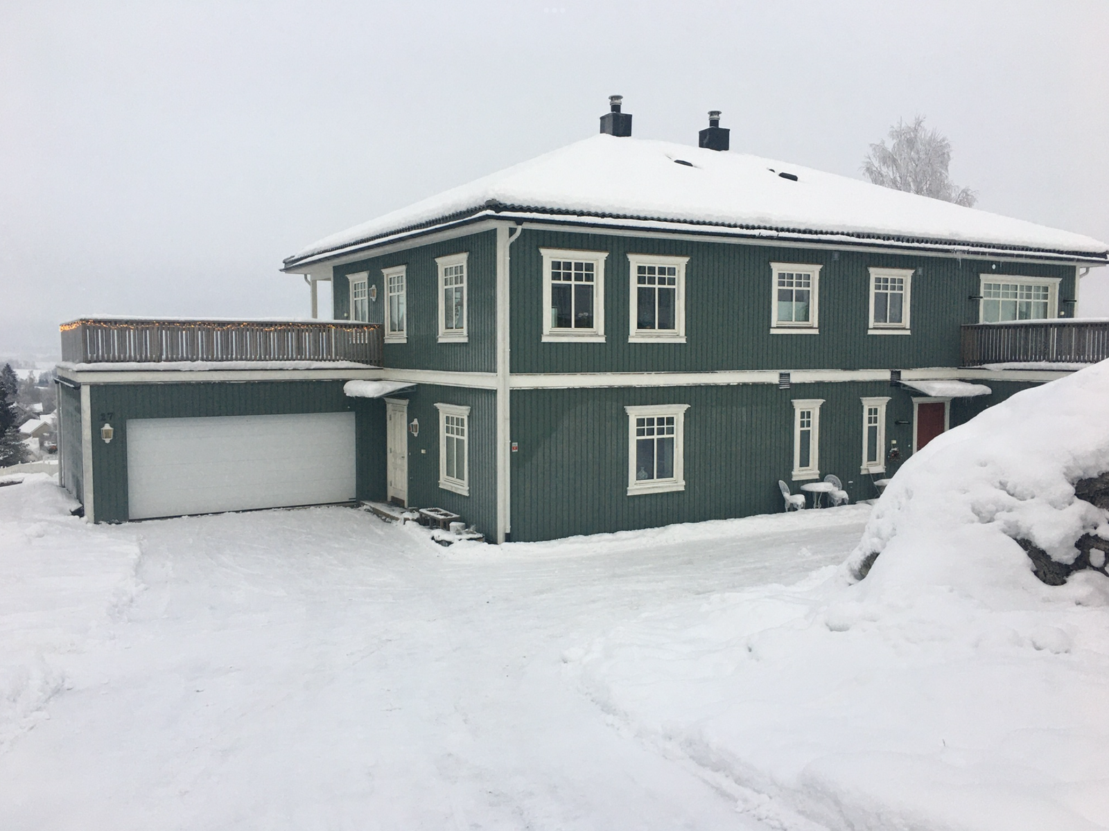 Stor gårdsplass med to doble garasjer og flere biloppstillingsplasser. Galleribilde