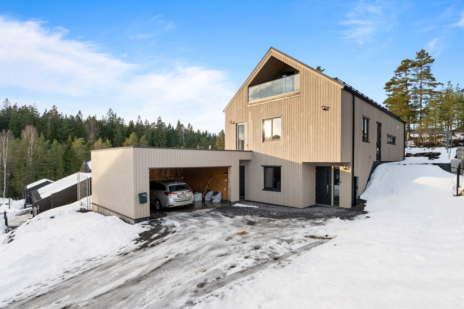 Boligen har en moderne fasade, gruslagt innkjørsel og garasje med takterrasse! Galleribilde
